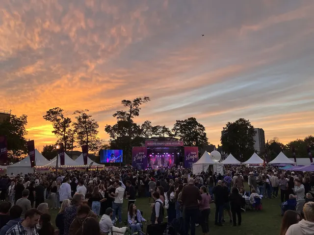 Crowd in front of an outdoor festival stage at sunset