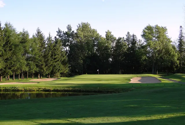 Green and sand trap lined with conifers on a Quebec golf course
