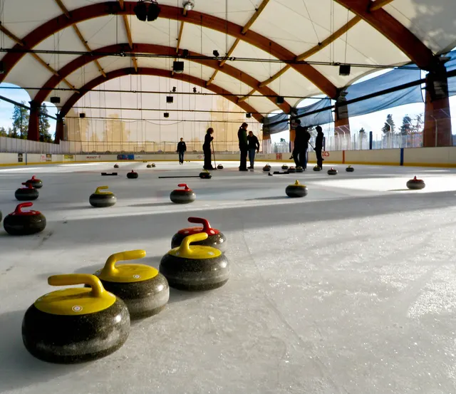 Curling stones lined up on the ice of a curling club