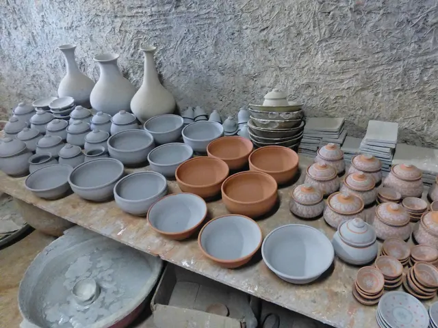 Bols et vases en céramique qui sèchent dans un atelier de poterie