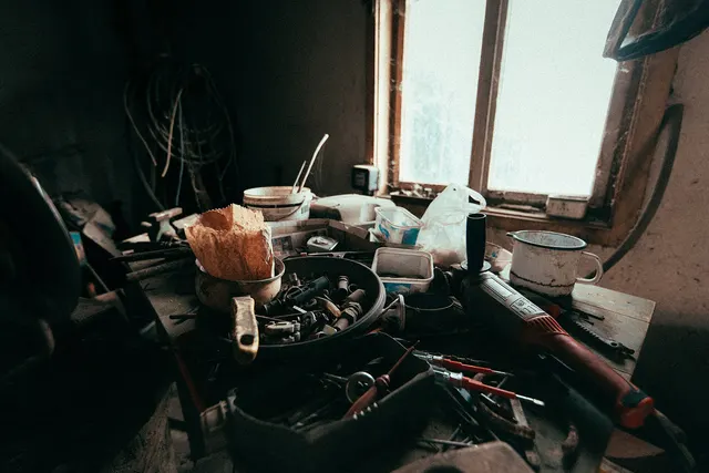 Établi encombré d'outils dans un vieil atelier rustique