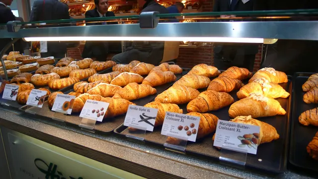 Filled croissants lined up in a bakery display case