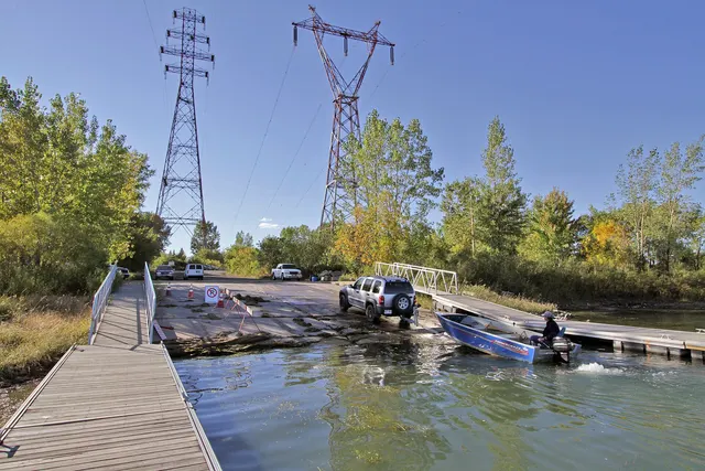 Mise à l'eau d'un bateau depuis une rampe, à côté d'un quai de bois, à Pointe-aux-Trembles