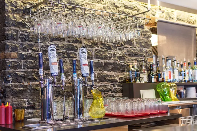 Bar counter with beer taps against a stone wall in Old Quebec