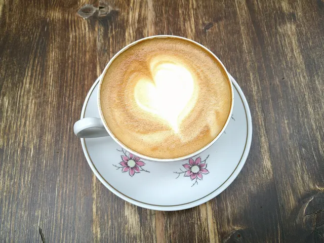 Cappuccino with a heart drawn in the foam on a wooden table