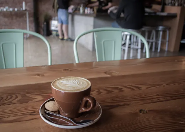 Cup of cappuccino on a wooden counter in a small café