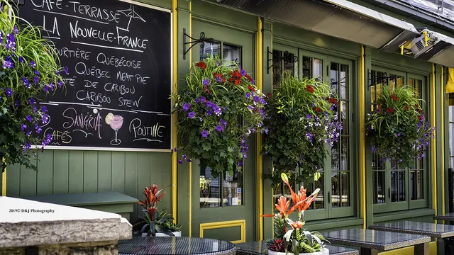 Café terrace with flower baskets and a chalkboard in Quebec City