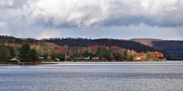 Lac Simon in autumn, with cottages and coloured hills on the far shore