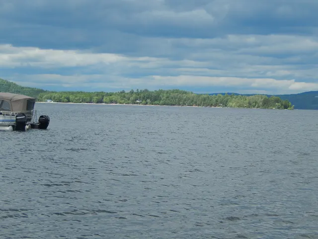 Pontoon boat on Lac Simon under a cloudy June sky