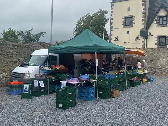 Vegetable stall under a green tent at a farmers' market