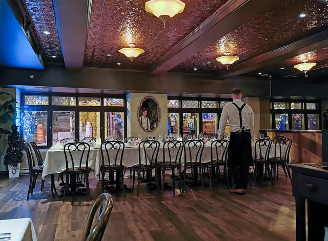 Dining room of an Old Quebec inn with white tablecloths and a pressed-tin ceiling