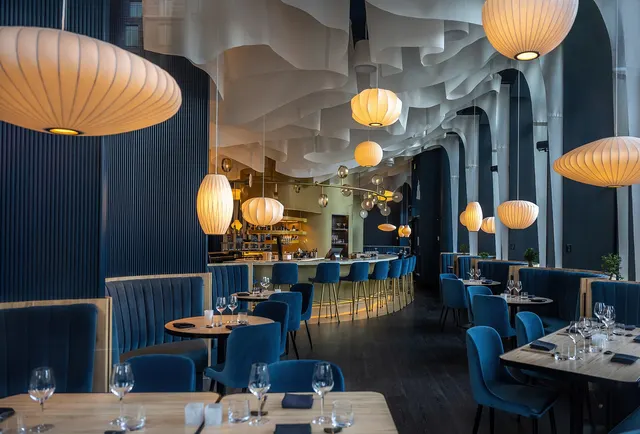 Modern restaurant with blue banquettes and globe lamps on Place D'Youville, Quebec City