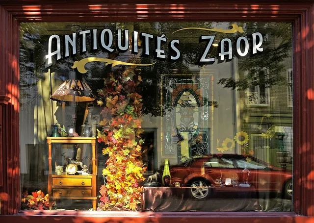 Window of an antique shop decorated with autumn leaves in Quebec City