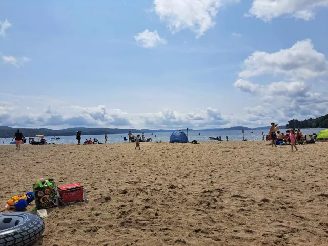 The wide sandy beach on Lac Simon at the tourist centre, with swimmers in the distance