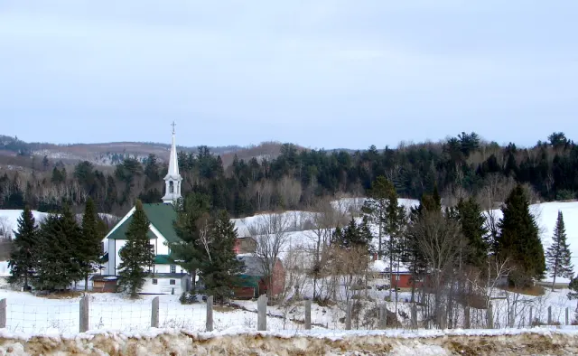 The village of Mayo and its white-steepled church in a snowy landscape