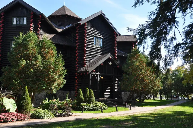 Log wings of the Château Montebello surrounded by trees and flower beds