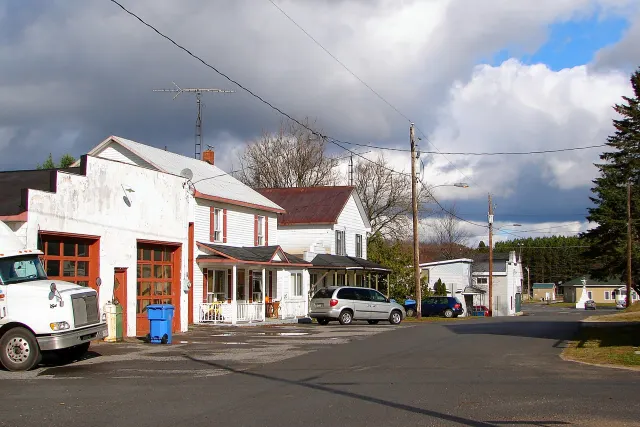 Village street in Notre-Dame-de-la-Paix with an old garage and houses