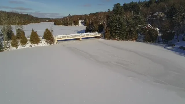 Bridge over frozen Lac Saint-Émile, conifer forest in December